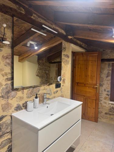 ein Badezimmer mit einem weißen Waschbecken und einem Spiegel in der Unterkunft La Casita de Verdiago in Verdiago