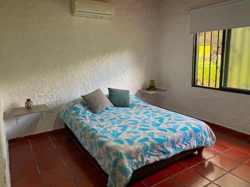 a bedroom with a bed with blue sheets and a window at Villa Zunilda in Rivera