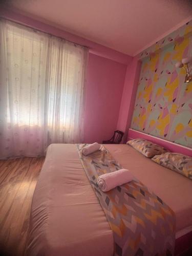 two beds in a room with pink walls at SWEET APARTMENT KUTaISI in Kutaisi