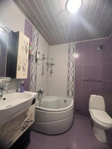 a bathroom with a sink and a tub and a toilet at SWEET APARTMENT KUTaISI in Kutaisi