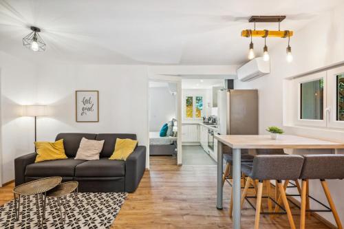 un salon avec un canapé et une table dans l'établissement Cosy & Chill Appartements - 10 min de la mer - Jardin, Netflix, terrasse, fibre & parking, à Cagnes-sur-Mer