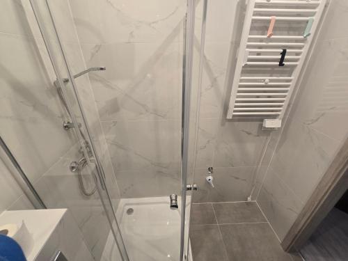 a bathroom with a shower with a glass door at Słoneczny Nadmorska in Grzybowo