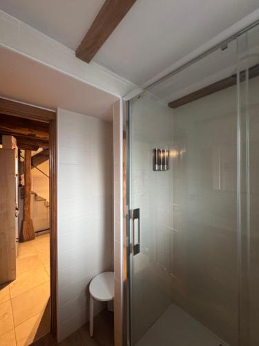 a glass shower in a bathroom with a chair at La Casita de Verdiago in Verdiago