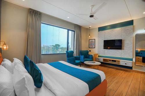 a hotel room with a bed and a flat screen tv at Hotel Highway Greens Near VR Punjab Mall Airport Road Mohali Chandigarh in Mohali