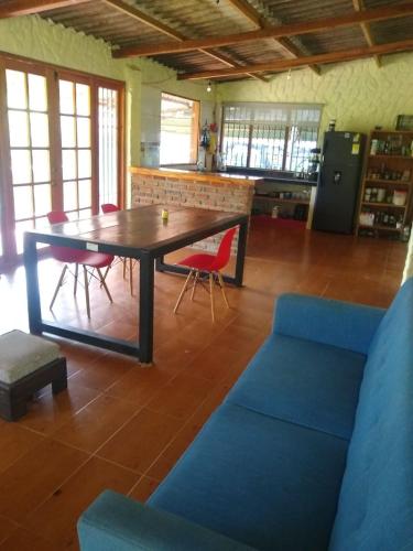 a living room with a wooden table and chairs at Bosque Azul in Minca