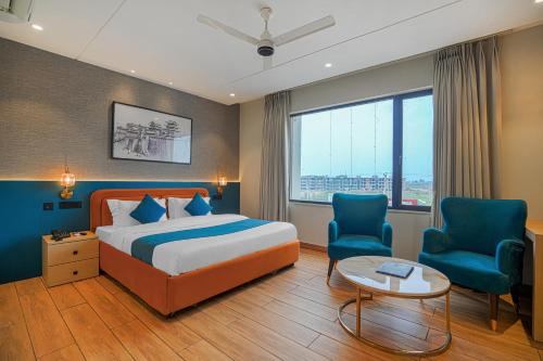 a hotel room with a bed and two chairs at Hotel Highway Greens Near VR Punjab Mall Airport Road Mohali Chandigarh in Mohali