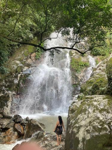 a woman standing in front of a waterfall at Bosque Azul in Minca