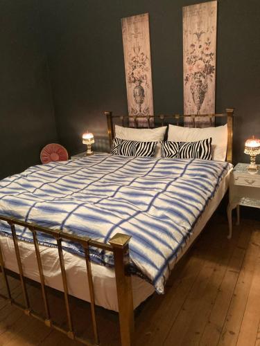 - un grand lit avec une couette à rayures bleue et blanche dans l'établissement Beautiful village home close to all attractions, à Saint-Sever-Calvados