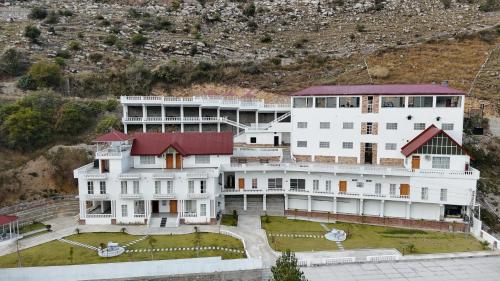 a large white building with a red roof at Destination Resort Thandiani in Abbottabad