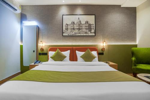 a bedroom with a large bed and a green chair at Hotel Highway Greens Near VR Punjab Mall Airport Road Mohali Chandigarh in Mohali