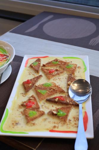 a plate of food on a table with a spoon at Destination Resort Thandiani in Abbottabad