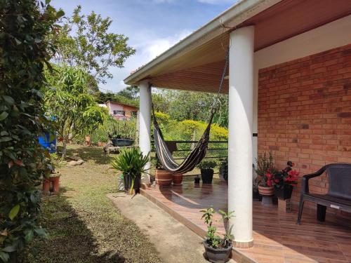 a porch with a hammock hanging from a house at Cabaña Rivera in Moniquirá
