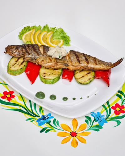 a plate of fish and vegetables on a plate at Resort EuroPark Fundata in Fundata