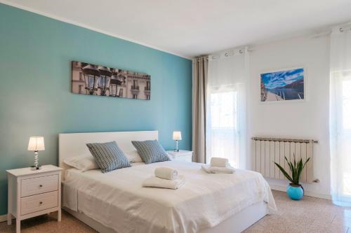 Un dormitorio con una gran cama blanca con paredes azules. en Casetta Lucia, en Desenzano del Garda