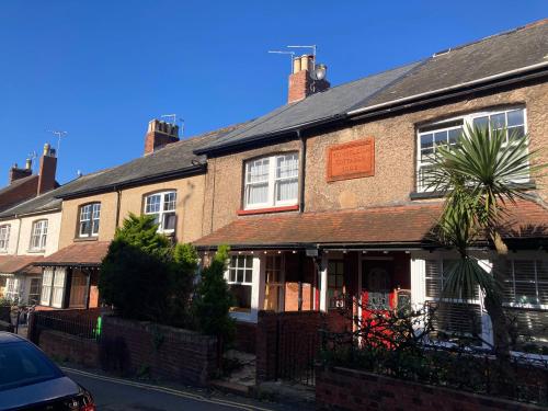 an old brick house with a palm tree in front of it at Sea Spirit Eco Guest House in Exmouth
