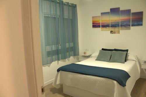 a bedroom with a bed with two pillows and a window at Apartamento Encanto Marino in Sant Carles de la Ràpita