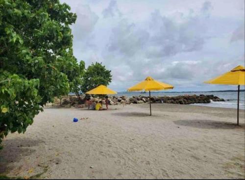 a beach with yellow umbrellas and people on the sand at Apartamento Cartagena en el laguito bocagrande vista al mar in Cartagena de Indias