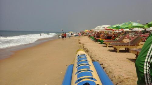 a beach with chairs and umbrellas and the ocean at Premium Luxury -1BHK at Candolim Beach with Free Wifi and Pool in Candolim