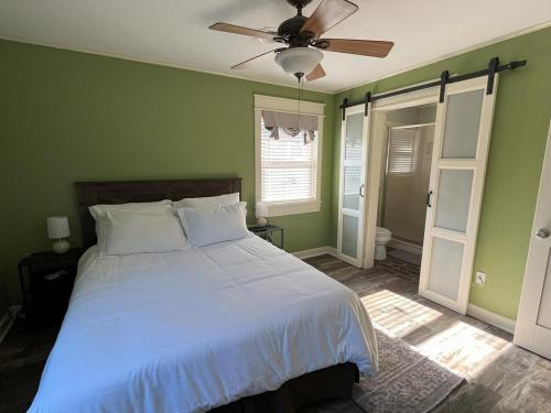 a bedroom with a white bed and a ceiling fan at Southern Bungalow Charm in Baton Rouge
