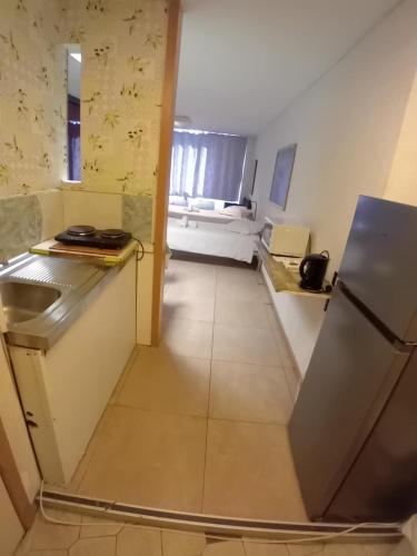 a kitchen with a sink and a refrigerator in a room at Apartotel Des Jardins De La Fontaine Qui Bout in Charleroi