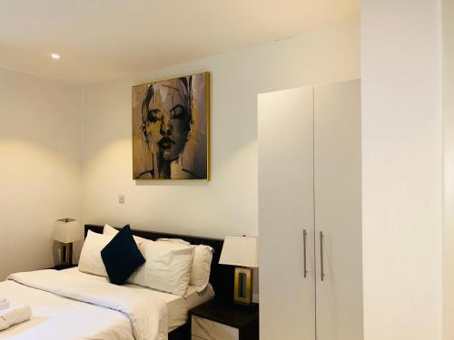 a bedroom with a bed and a painting on the wall at Cozy Abode by Embassy Gardens in Accra
