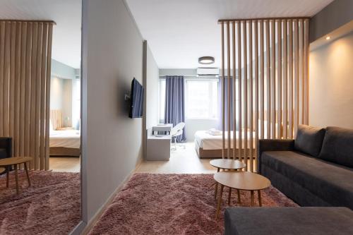 a living room with a couch and a bedroom at Tsimiski double suites #8 in Thessaloniki