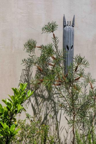 a plant with a statue of a rabbit on the side of a wall at Velvet Bungalow in Carvalhal