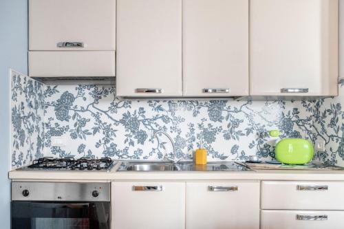 a kitchen with white cabinets and a stove top oven at Le Terrazze in Otranto