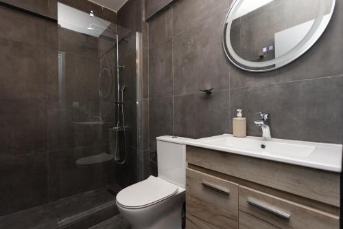 a bathroom with a toilet and a sink and a mirror at Tsimiski double suites #8 in Thessaloniki