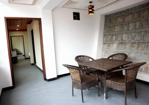 a dining room with a wooden table and chairs at Destination Resort Thandiani in Abbottabad