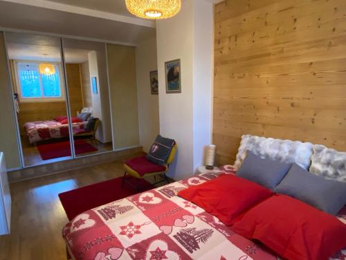 a bedroom with a bed and a chair and a mirror at Les Apparts de la Tourronde in Chorges