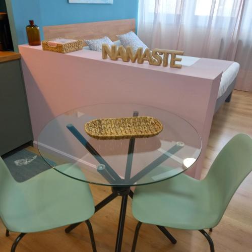 a glass table and two chairs in front of a counter at Le Ammiraglie 2 in Savona