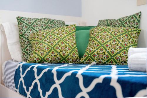 a bed with several pillows and a blue blanket at Le Terrazze in Otranto