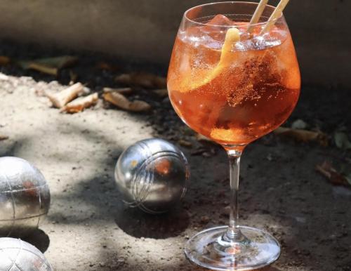 a drink in a glass sitting on a table with balls at Hotel Mercure Château de Fontainebleau in Fontainebleau