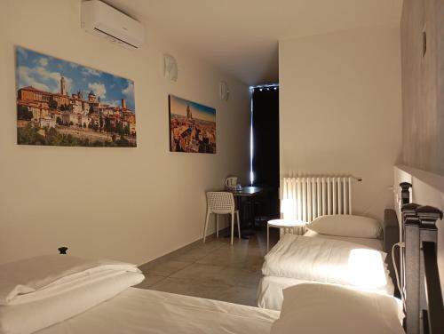 a bedroom with two beds and a desk in it at La Sosta in Grassobbio
