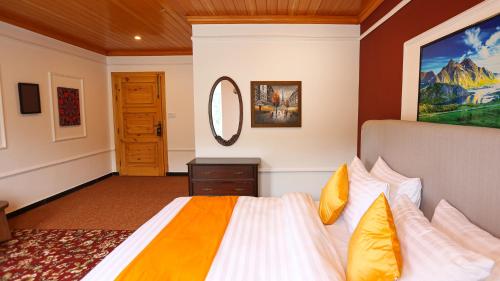a bedroom with a large bed and a mirror at Destination Resort Thandiani in Abbottabad