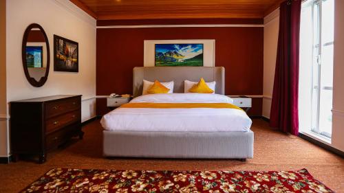 a bedroom with a large bed and a mirror at Destination Resort Thandiani in Abbottabad
