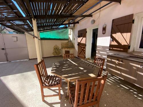 un patio avec une table et des chaises et une cuisine dans l'établissement L'Escale Marine Wifi Parking Proche port, à La Ciotat