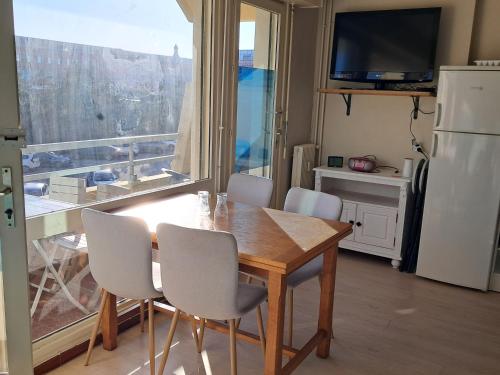 une cuisine avec une table et des chaises ainsi qu'une grande fenêtre dans l'établissement Évasion Berckoise, à Berck-sur-Mer