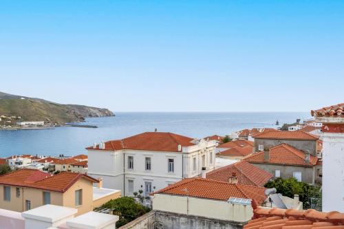 a view of roofs of houses and the ocean at Archontiko Eleni Hotel in Andros