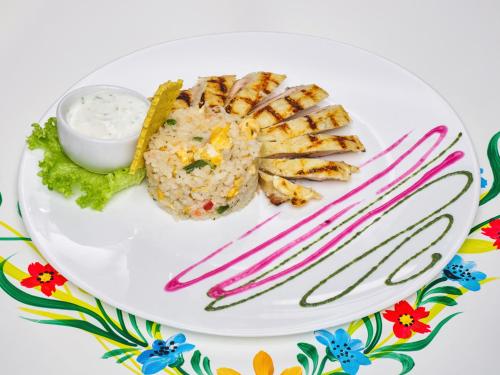 a plate of food with shrimp and dipping sauce at Resort EuroPark Fundata in Fundata