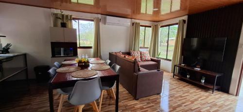 a living room with a table and chairs and a television at House of Dreams in Nicoya