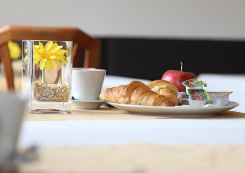 a plate of croissants and an apple on a table at Penzión Bojnice in Bojnice