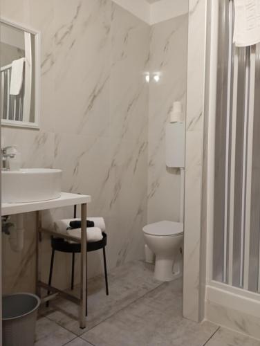 a white bathroom with a sink and a toilet at La Sosta in Grassobbio