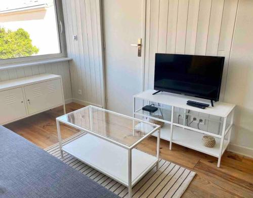 un salon avec une télévision et une table en verre dans l'établissement Beautiful studio 200 from tram B, à Talence