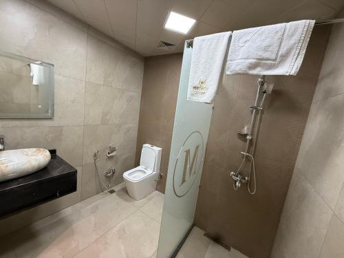 a bathroom with a shower and a toilet and a sink at Black Mont İnn Hotel in Baku