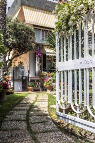 a white fence in front of a house at Alden in Formia