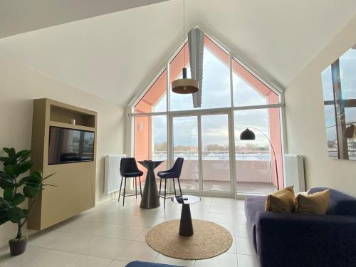 a living room with a couch and chairs and a large window at La Suite Design Dunkerque Plage à 50 mTerrasse Sud in Dunkerque