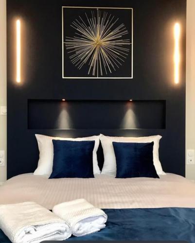 une chambre avec un grand lit avec des oreillers bleus et blancs dans l'établissement La Suite Design Dunkerque Plage à 50 mTerrasse Sud, à Dunkerque