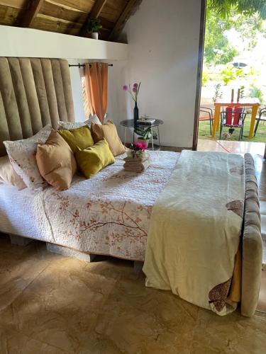 a bedroom with a large bed with pillows at Dreamvilles Ecovillage Las Galeras in Las Galeras